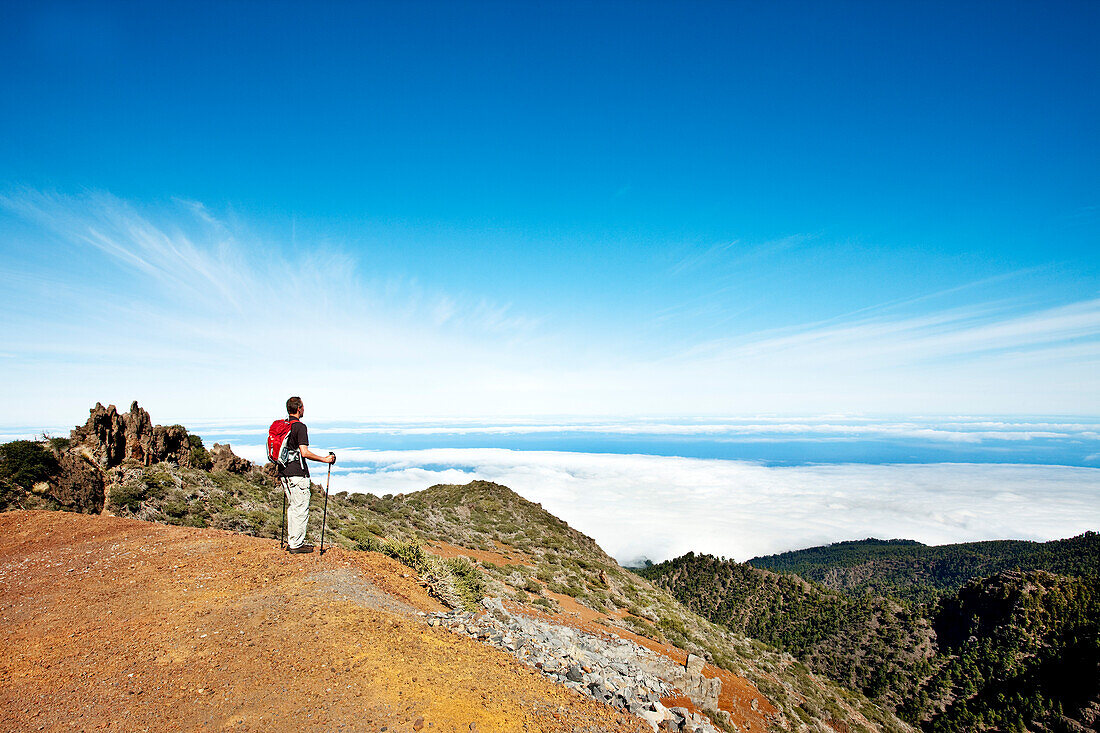 Wanderer auf einem Berg blickt auf Wolkendecke, Roque de los Muchachos, Caldera de Taburiente, La Palma, Kanarische Inseln, Spanien, Europa