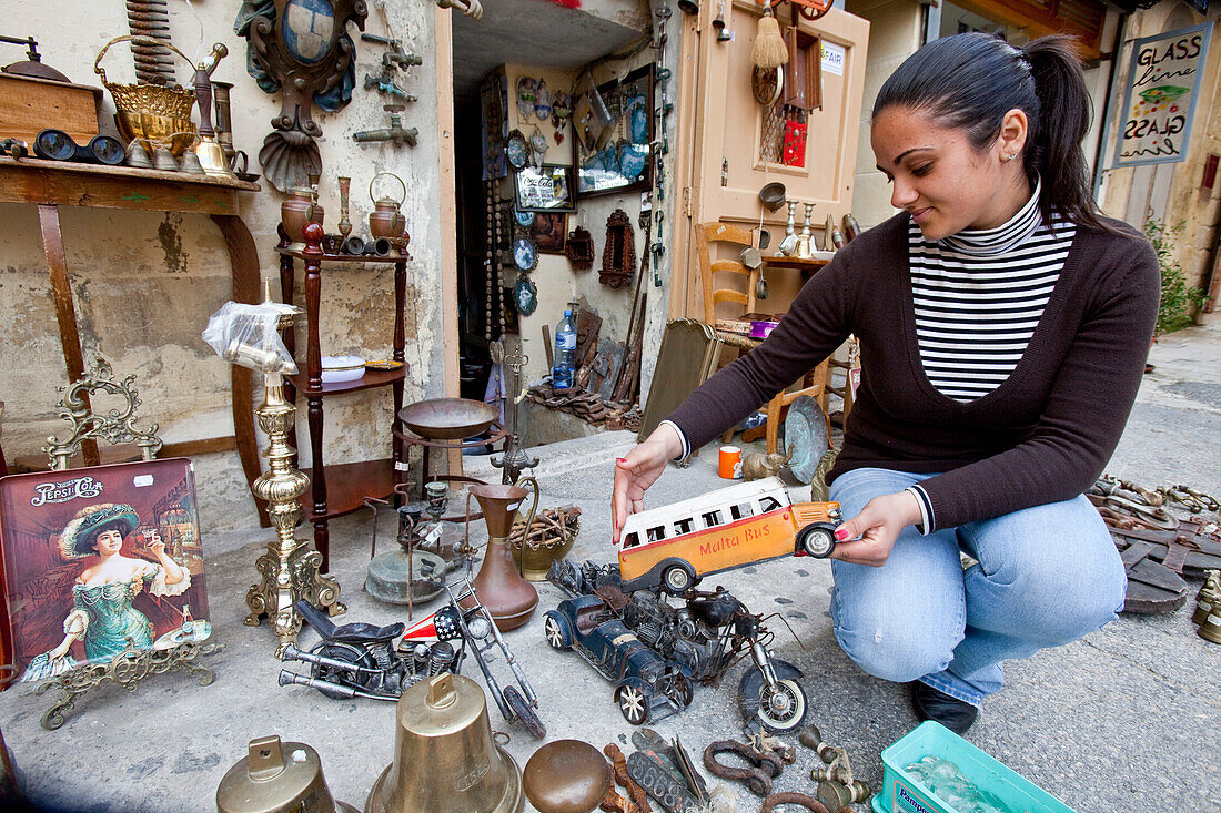 Eine junge Frau verkauft Antiquitäten in Victoria, Gozo, Malta, Europa