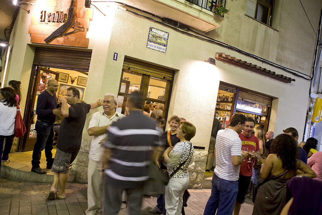People standing in front of a Tapas restaurant in the evening, Calle de Barcelona, Sitges, Catalonia, Spain, Europe