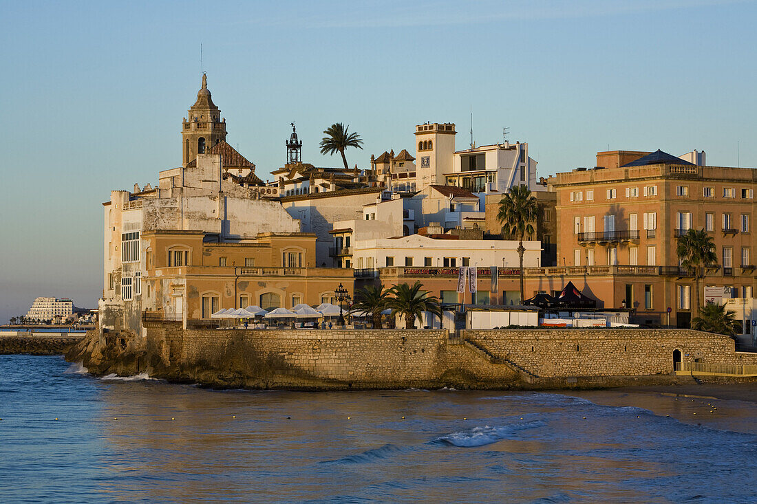 Steeple of the cathedral and houses on the waterfront in the evening light, Sitges, Catalonia, Spain, Europe