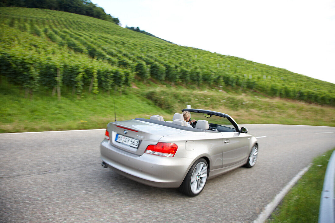 Cabrio auf einer Landstraße zwischen Weinbergen, bei Baden-Baden, Baden-Württemberg, Deutschland