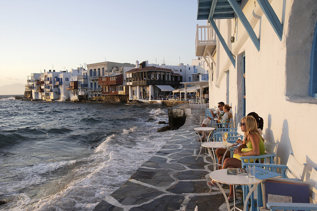 Menschen auf der Terrasse einer Bar in der Abendsonne, Klein Venedig in Mykonos, Griechenland, Europa