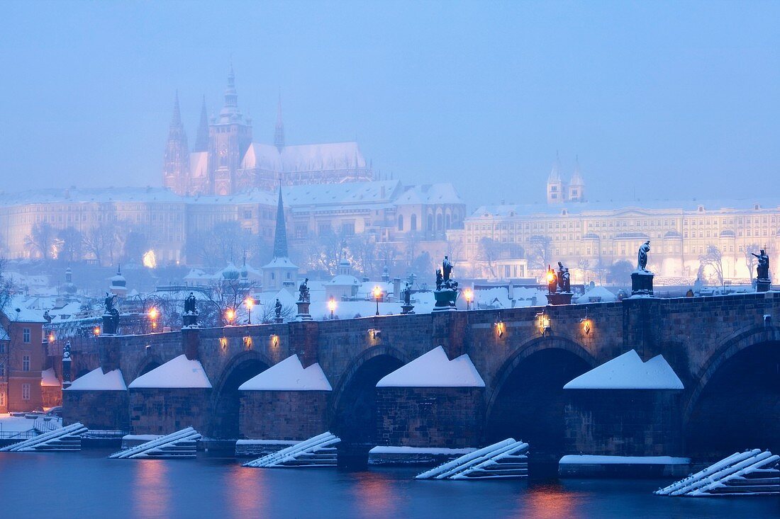 prague - charles bridge and hradcany castle during heavy snowfall