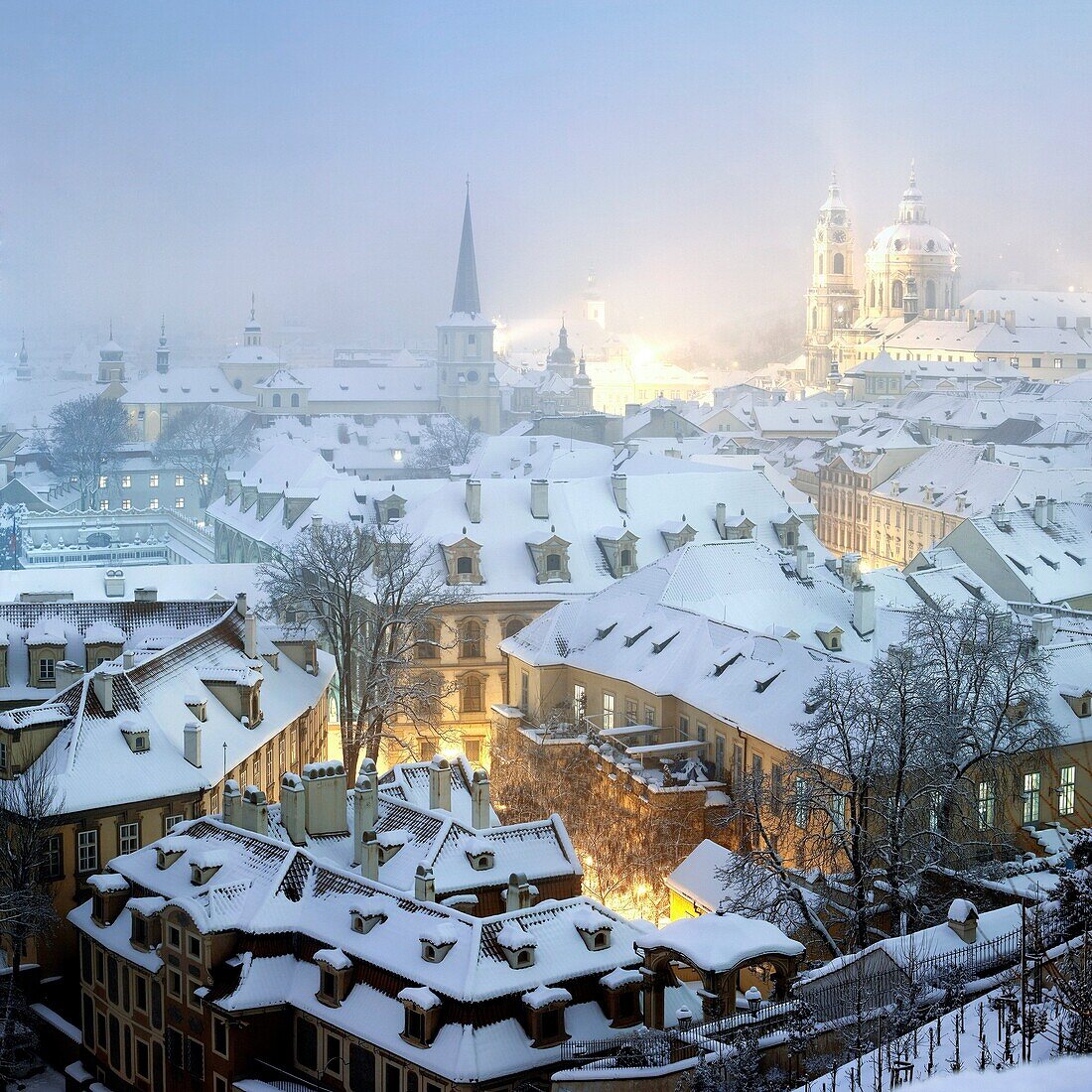 prague - winter view of mala strana rooftops covered with snow