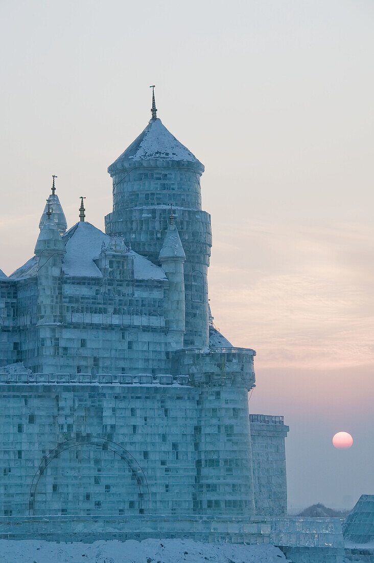 China. Heilongjiang. HAERBIN  Harbin): Haerbin Ice and Snow World Festival. All Buildings built of ice. Ice Church at Sunset