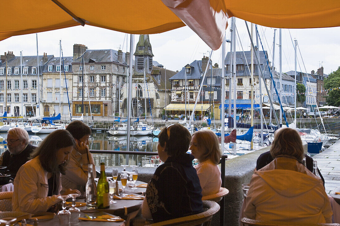 One of the restaurant along the Vieux Bassin  Old Port) with Saint-Etienne church  now Naval Museum) in background, Honfleur. Calvados, Basse-Normandie, France