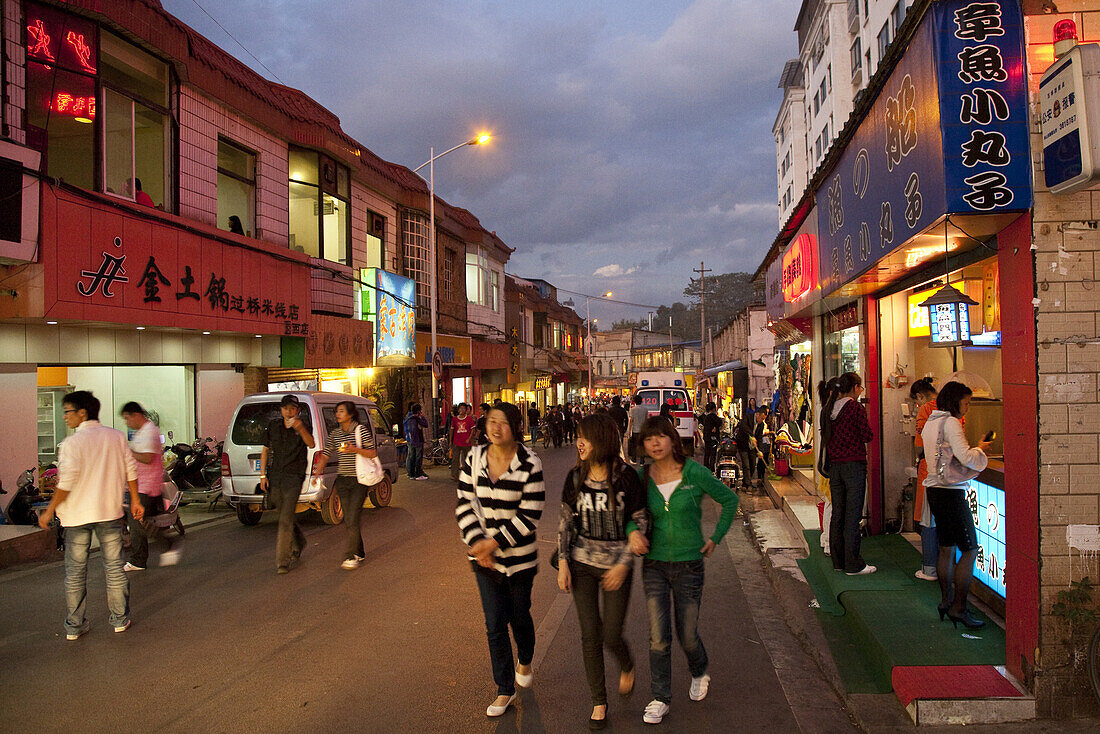 Jugendliche und Studenten auf der YuanXi Strasse in der Abenddämmerung, Einkaufsstrasse mit Cafes und Restaurants, Kunming, Yunnan, Volksrepublik China, Asien