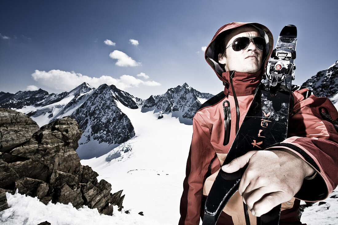 Junger Mann mit Telemark-Ski auf der Schulter vor Oestlicher Seespitze, Westlicher Seespitze und Ruderhofspitze, Wildgratscharte, Stubaier Alpen, Tirol, Oesterreich, MR