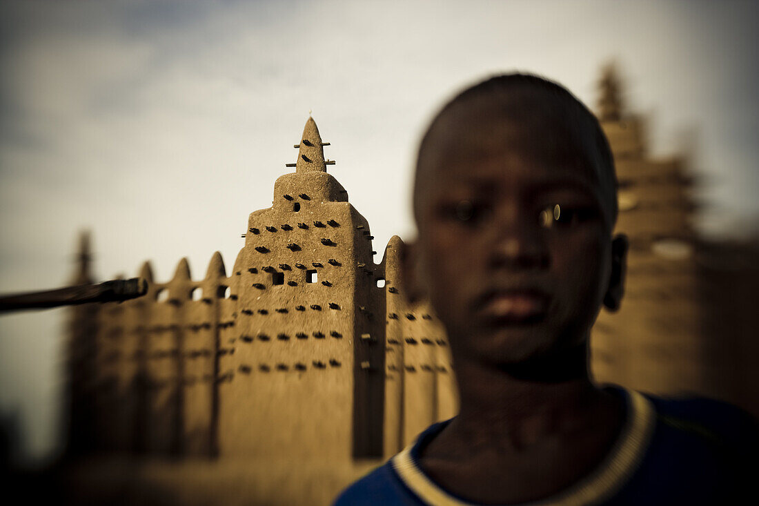 African boy in front of the mosque of Djenna, Mali, Africa
