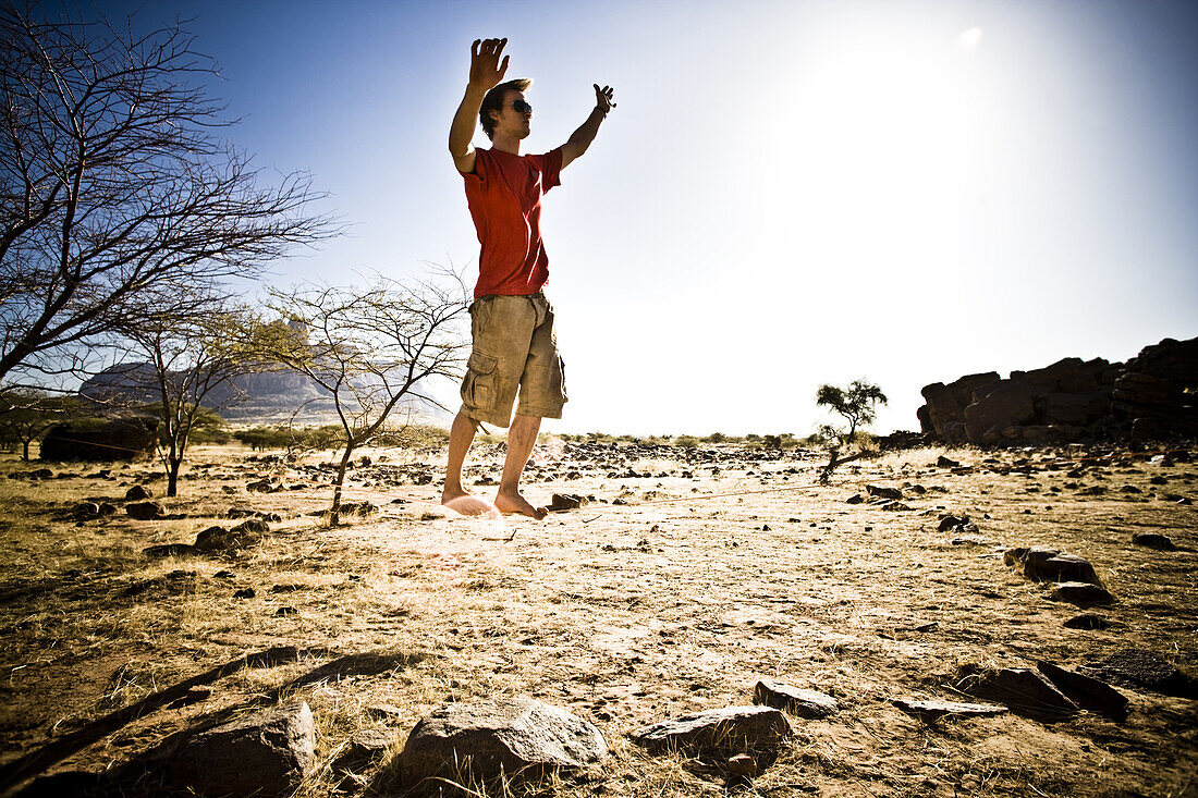 Junger Mann auf balanciert auf Slackline, Hand der Fatima, Hombori, Mali, Afrika
