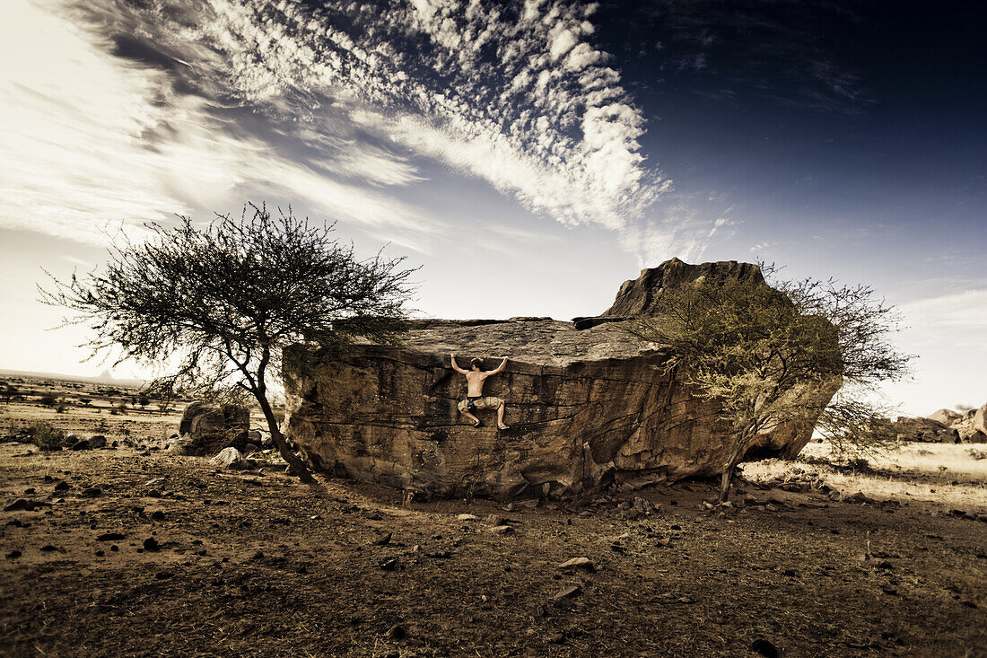 Young man bouldering on a rock, Hand of Fatima, Hombori, Mali, Africa