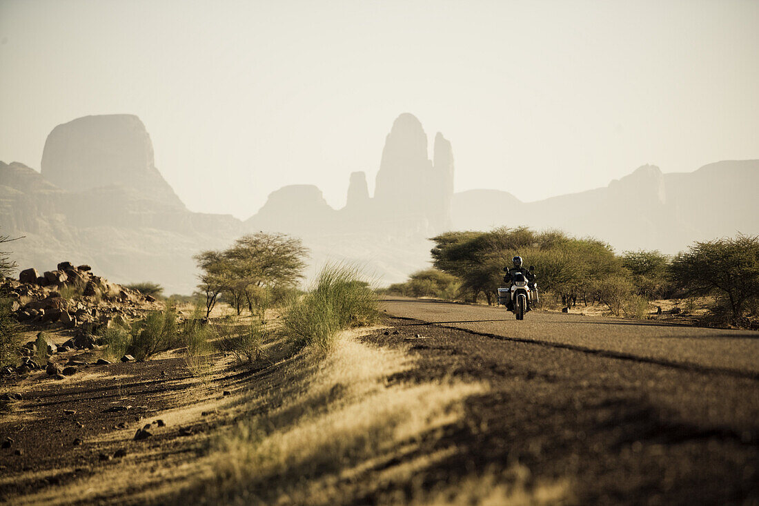 Motorradfahrer auf Strasse vor der Hand der Fatima, Mali, Afrika