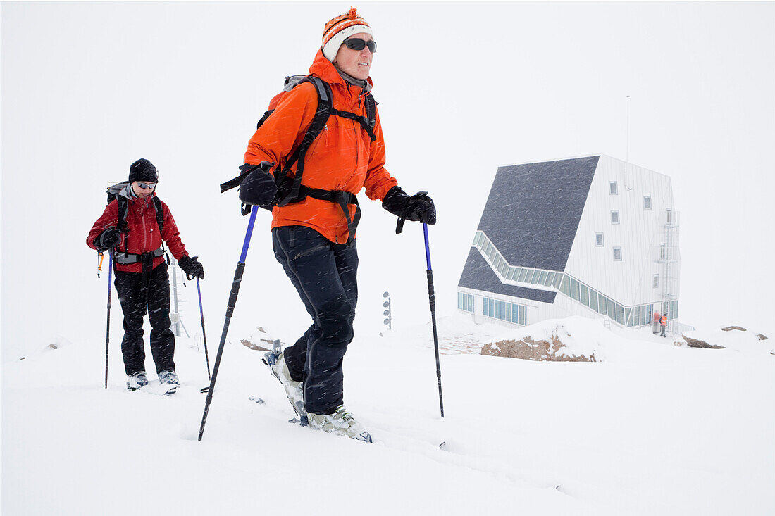 Zwei Skitourengeherinnen im Schneesturm, Monte-Rosa-Hütte im Hintergrund, Kanton Wallis, Schweiz