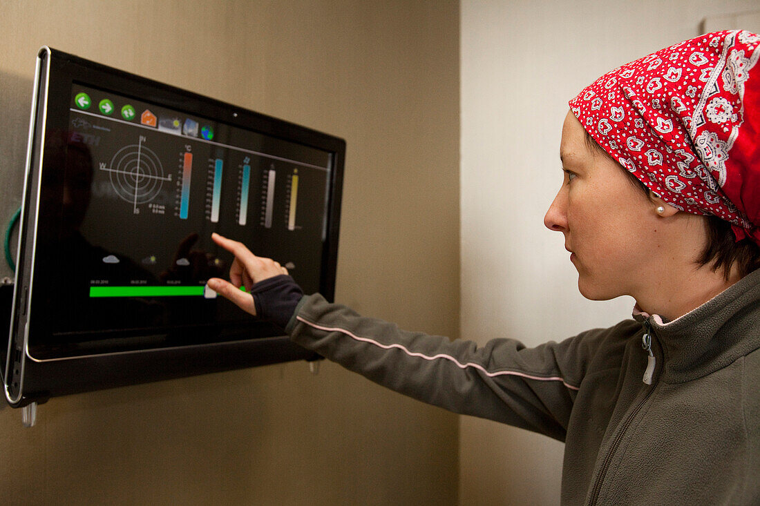 Frau bedient Touchscreen, Neue Monte-Rosa-Hütte, Zermatt, Kanton Wallis, Schweiz