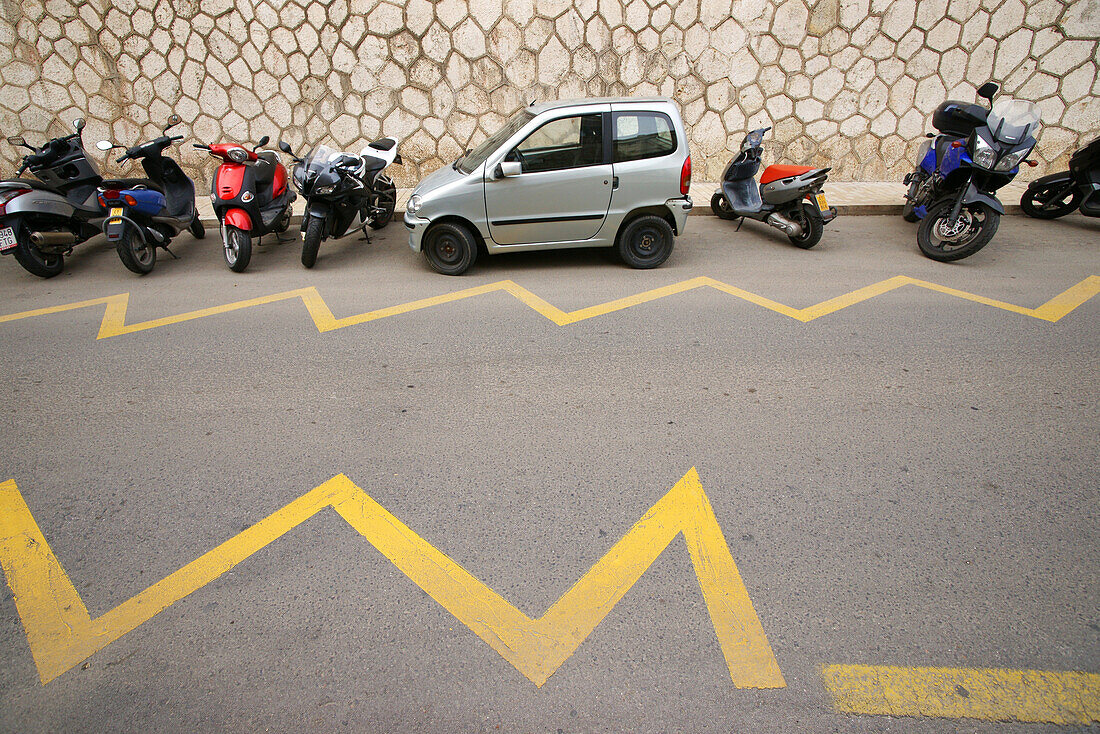 Car and scooters in a street in Malaga, Spain, Europe