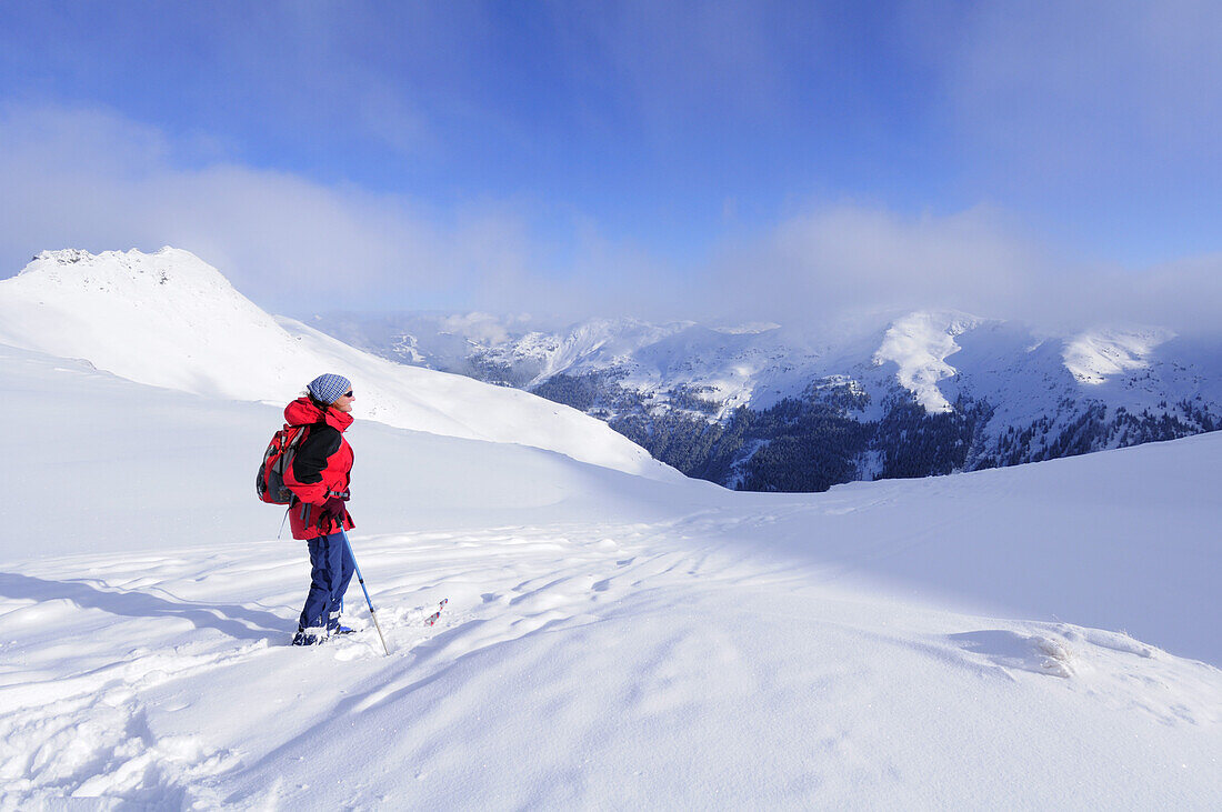 Woman back country skiing enjoying the view towards the Kitzbuehel mountain range, Schusterkogel, Saalbach-Hinterglemm, Kitzbuehel range, Salzburg, Austria