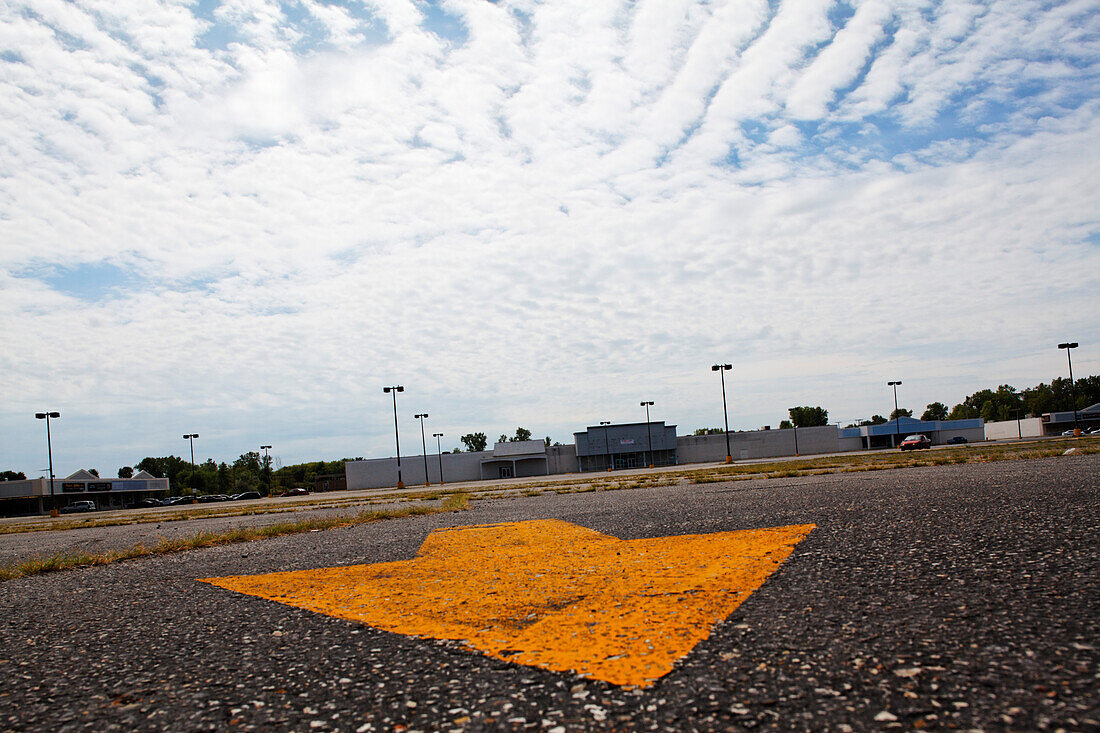 Painted arrow on the parking lot of an abandoned shopping mall, Michigan City, Indiana, USA