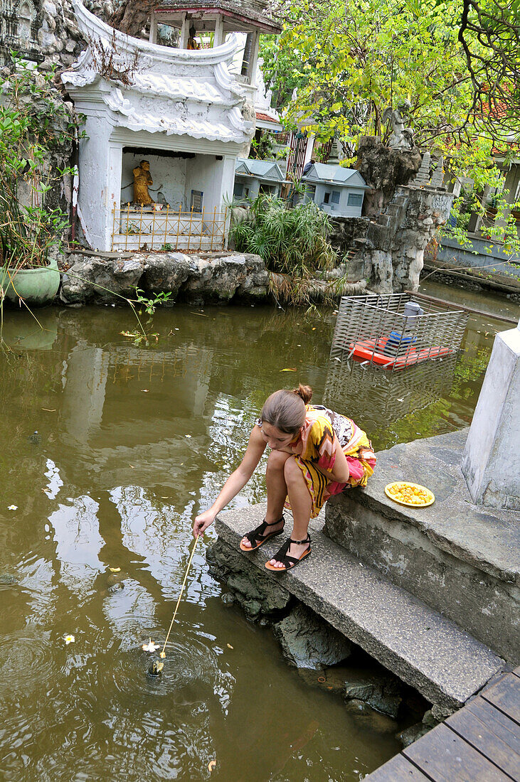 Girl at turtle pond in the Wat Prayunrawonsawatt, Bangkok, Thailand, Thailand, Asia