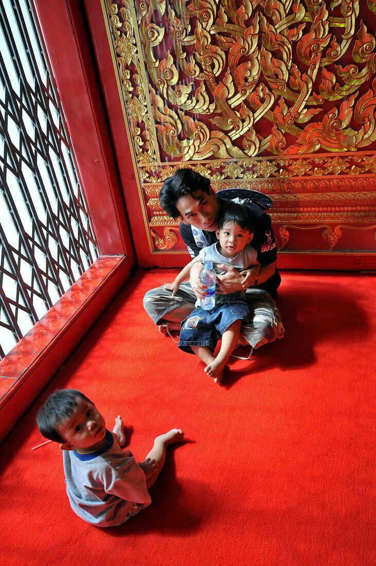 Mann mit Kindern im Wat Mongkol Bobit Tempel, alte Königsstadt Ayutthaya, Thailand, Asien
