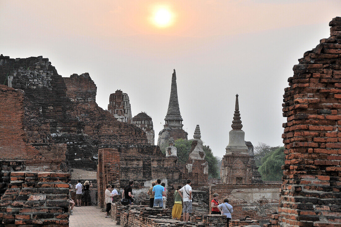 Touristen am Wat Mahathat Tempel bei Sonnenuntergang, alte Königsstadt Ayutthaya, Thailand, Asien
