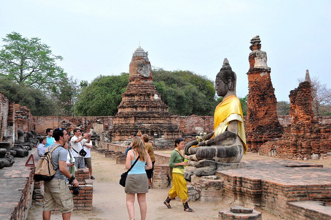 Touristen an der Buddhastatue am Wat Mahathat Tempel, alte Königsstadt Ayutthaya, Thailand, Asien