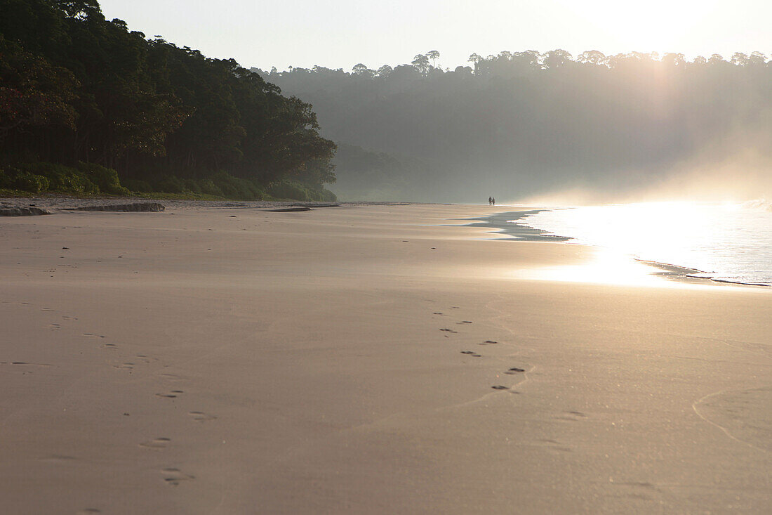 Couple walking along Radha Nagar Beach at sunrise, Beach 7, Havelock Island, Andamans, India