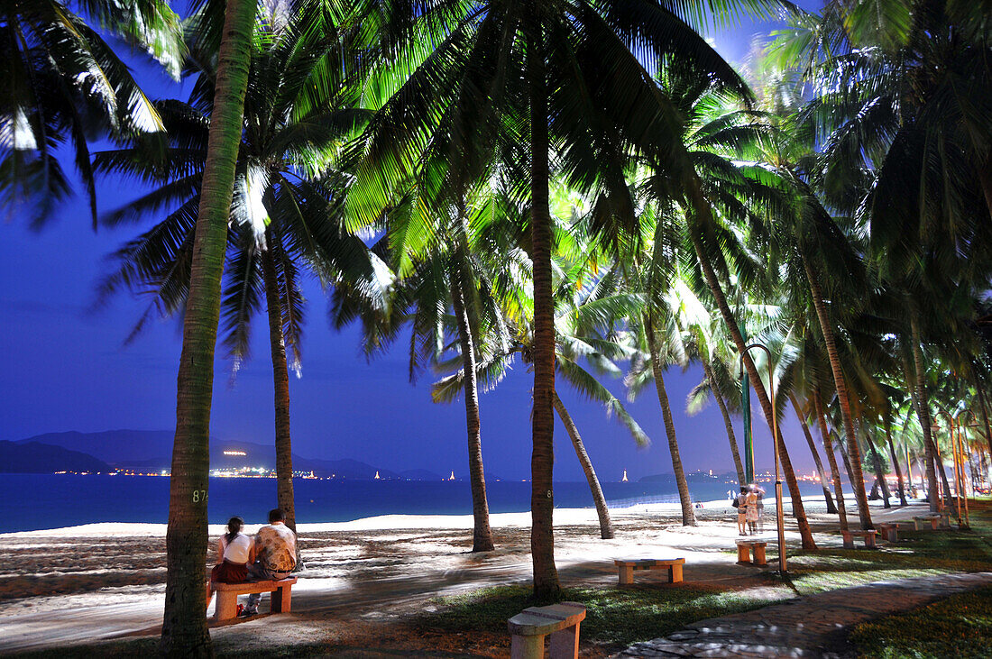 Couple sitting on the beach at night, Nha Trang, Vietnam