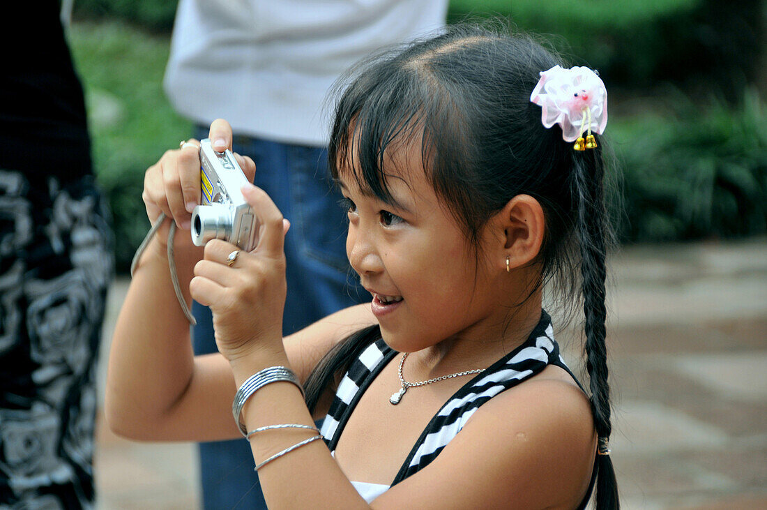 Junges Mädchen beim Fotografieren im Literatur Tempel, Ba Dinh-Viertel, Hanoi, Vietnam
