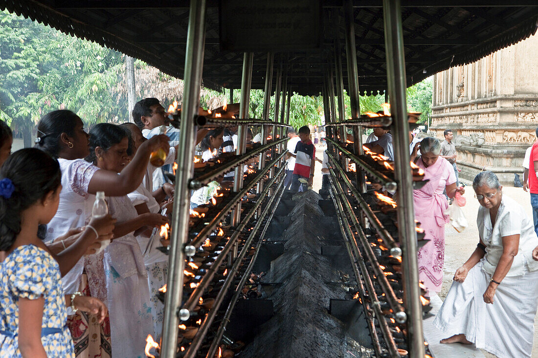 Buddhists lighting oil lamps at the Kelaniya Raja Maha Vihara temple, Colombo, Sri Lanka, Asia