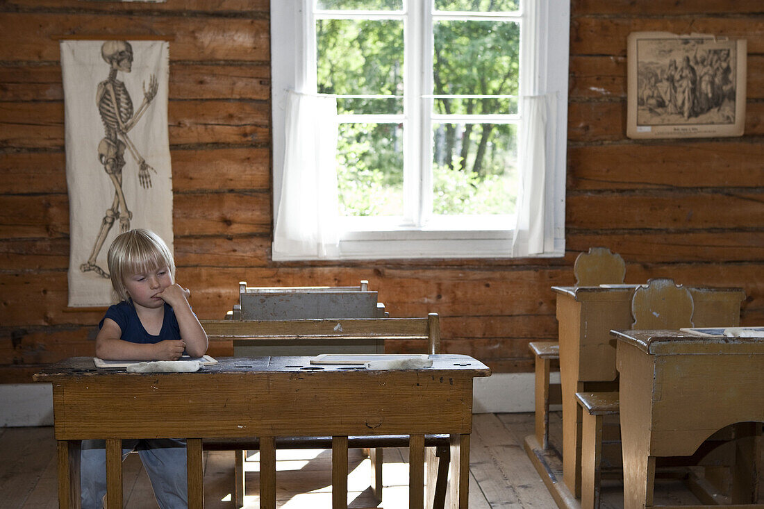 A little girl in an old classroom, open air museum Gammlia, Umea, Vaesterbotten, Sweden, Europe