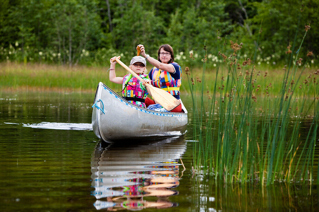 A girl and a woman in a canoe on the island of Norrbyskaer, Vaesterbotten, Sweden, Europe