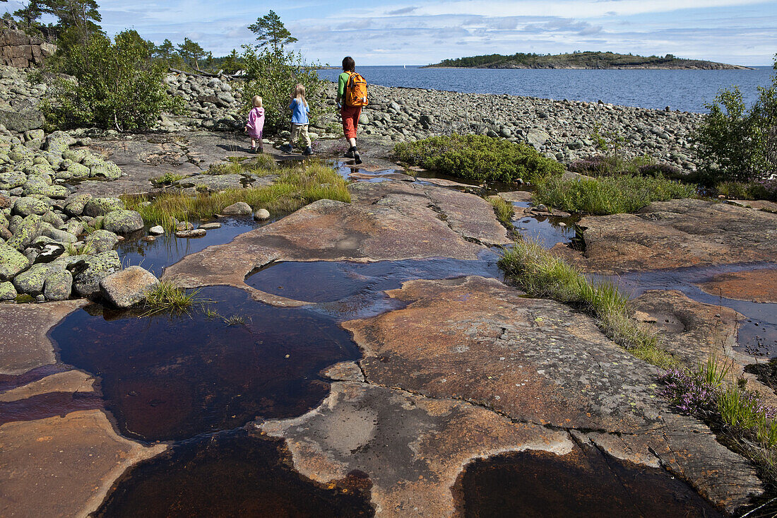 A woman and two girls hiking in the nature reserve Rotsidan, Höga Kusten, Västernorrland, Sweden, Europe