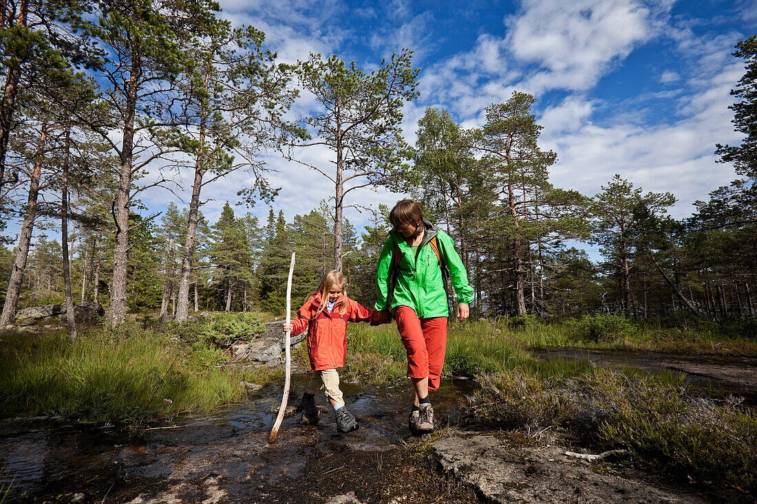 Eine Frau und zwei Mädchen wandern im Naturschutzgebiet Rotsidan, Höga Kusten, Västernorrland, Schweden, Europa