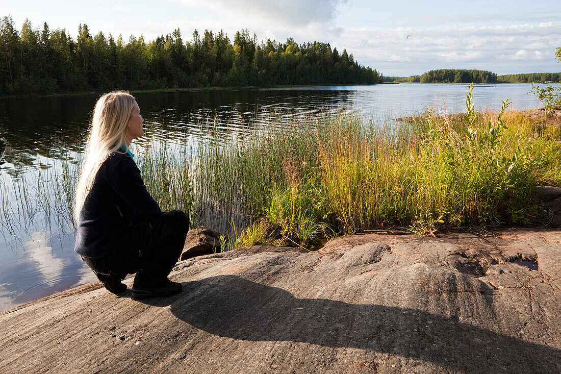 Eine Frau schaut über einen See, Västerbotten, Schweden, Europa