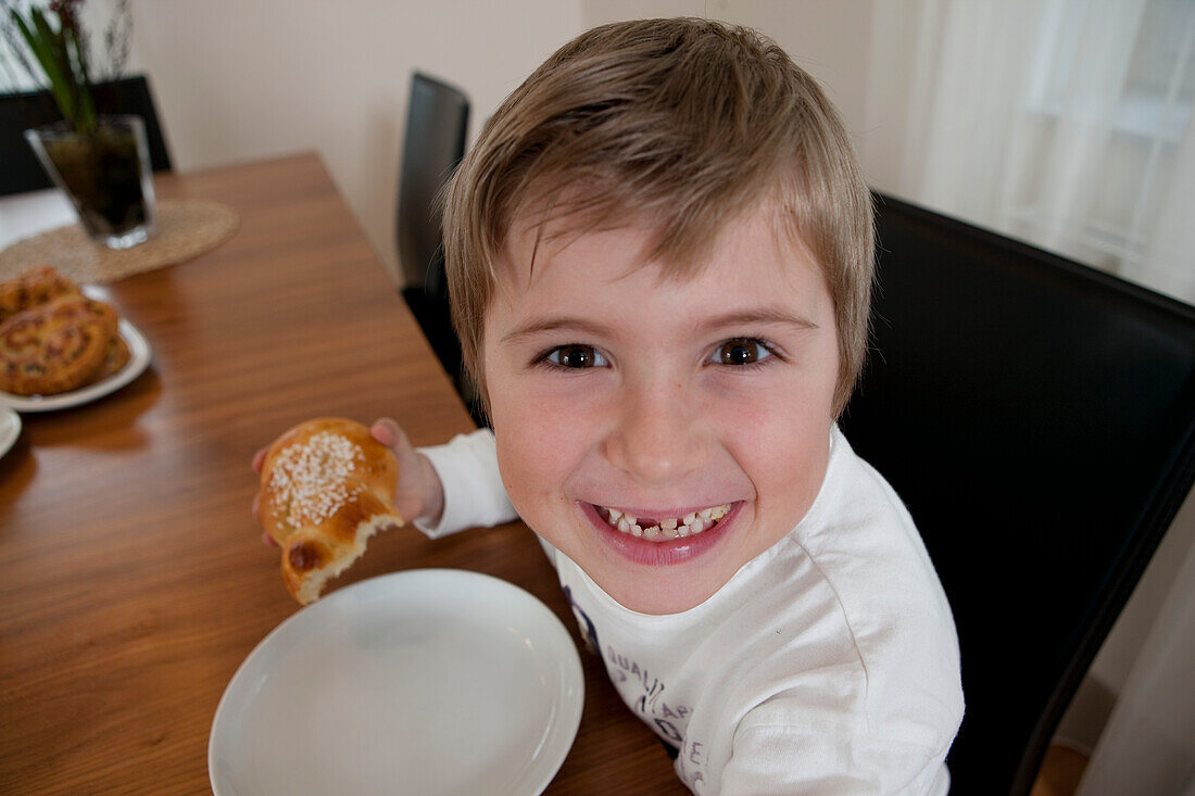 Junge (6 Jahre) isst Gebäck