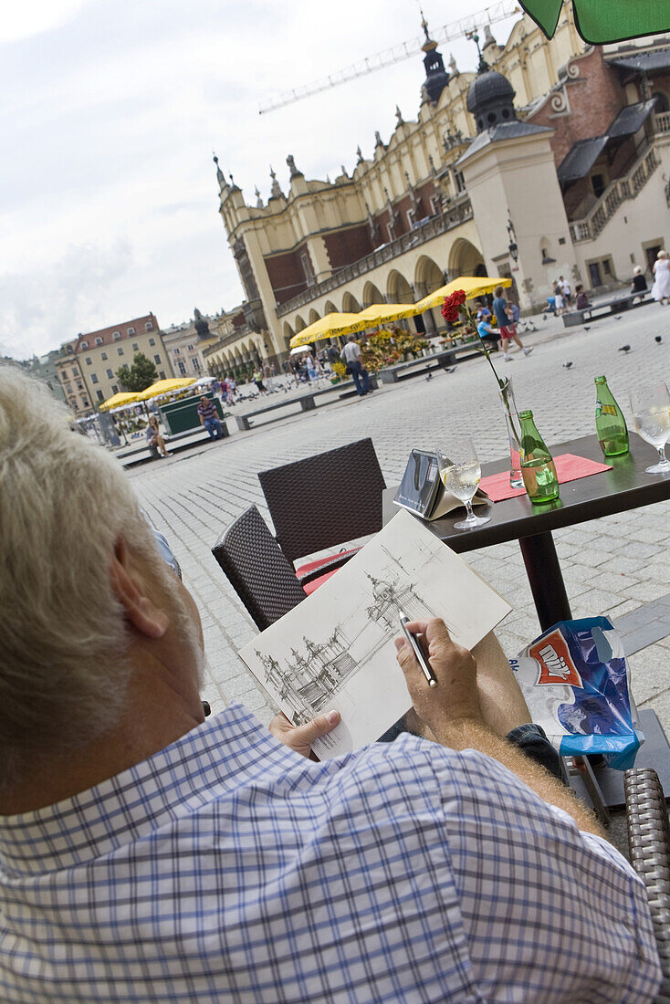 Mann skizziert die Tuchhalle am Hauptmarkt Rynek Glowny, Krakau, Polen, Europa