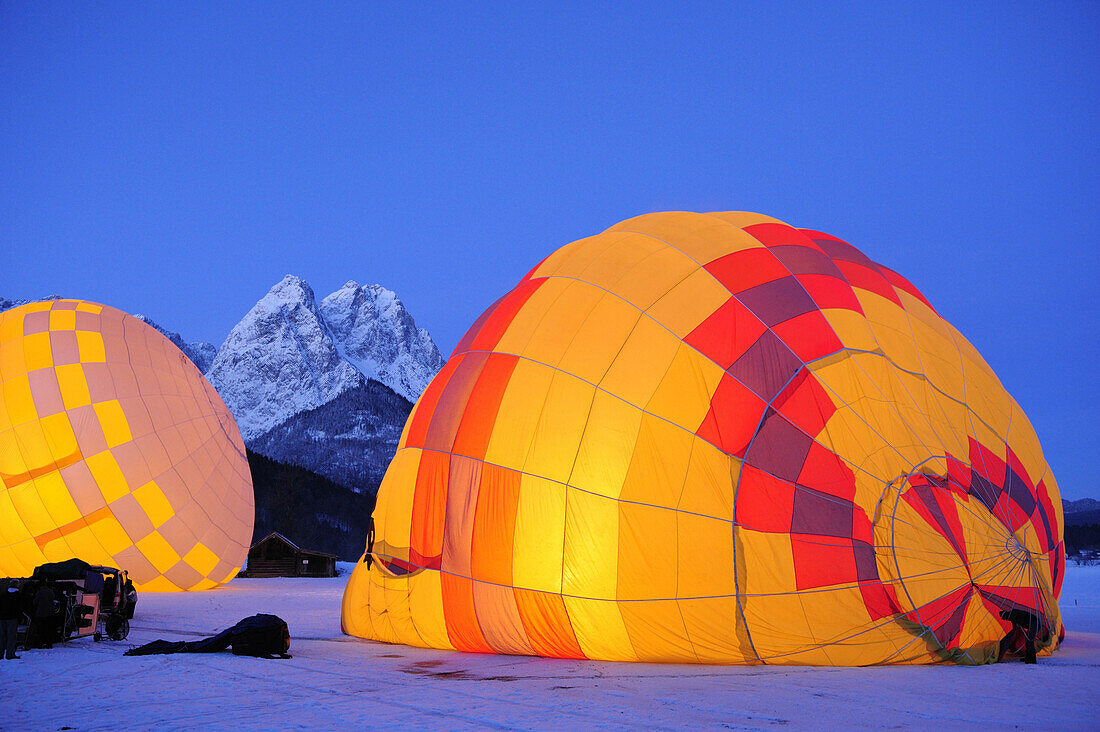 Two hot-air balloons lying on the ground and being filled, Waxensteine in background, Garmisch-Partenkirchen, Wetterstein range, Bavarian alps, Upper Bavaria, Bavaria, Germany, Europe