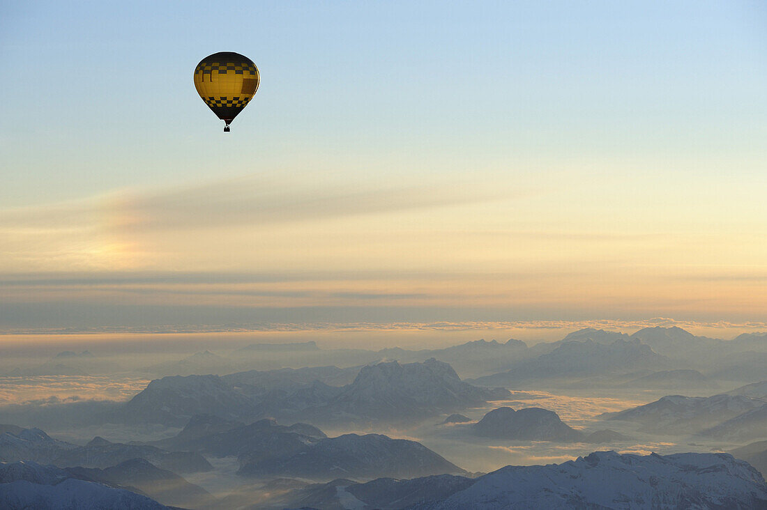 Luftaufnahme von Heißluftballon über Kaisergebirge bei Sonnenaufgang, Berchtesgadener Alpen im Hintergrund, Tirol, Österreich, Europa