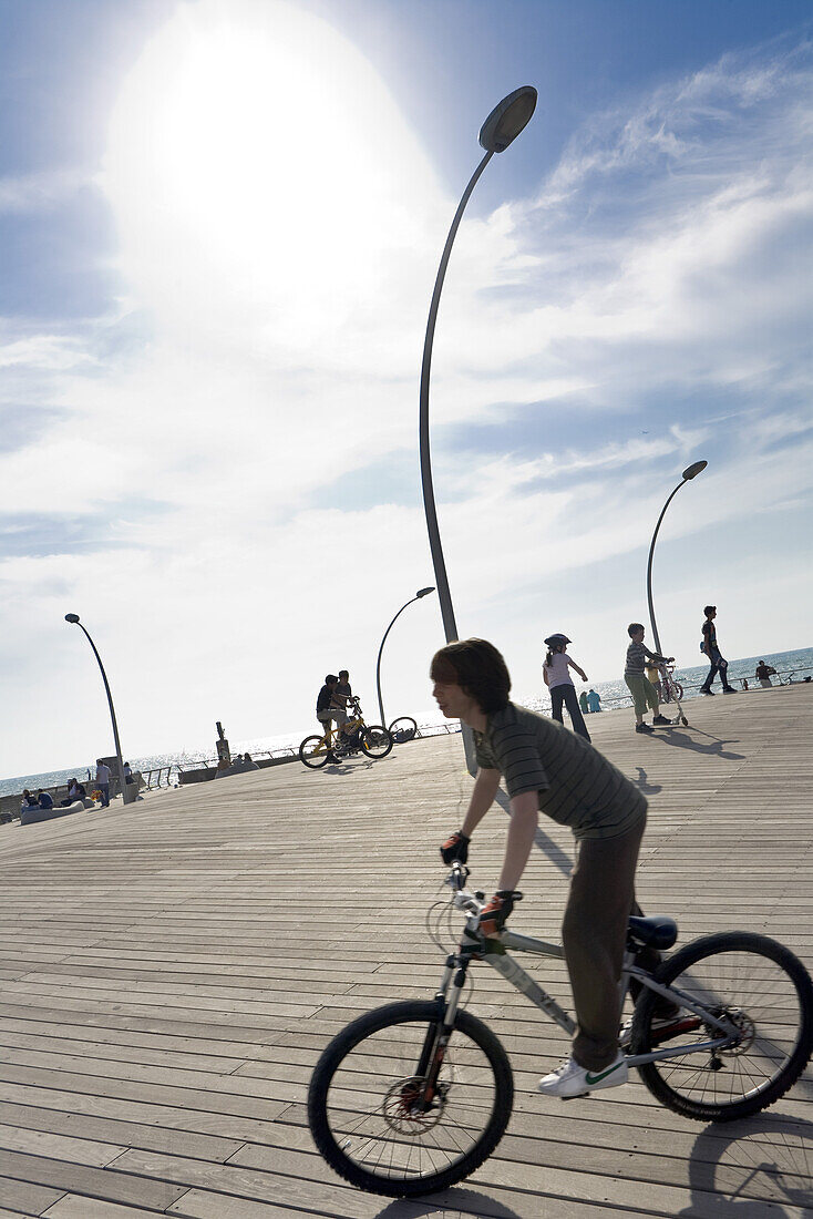 Boy riding a bike at the seaside promenade, Namal section of Tel Aviv, Israel, Middle East