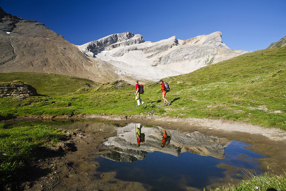 Two women hiking through Val Gronda to Fuorcla Starlera, mount Wissberg in background, Canton of Grisons, Switzerland