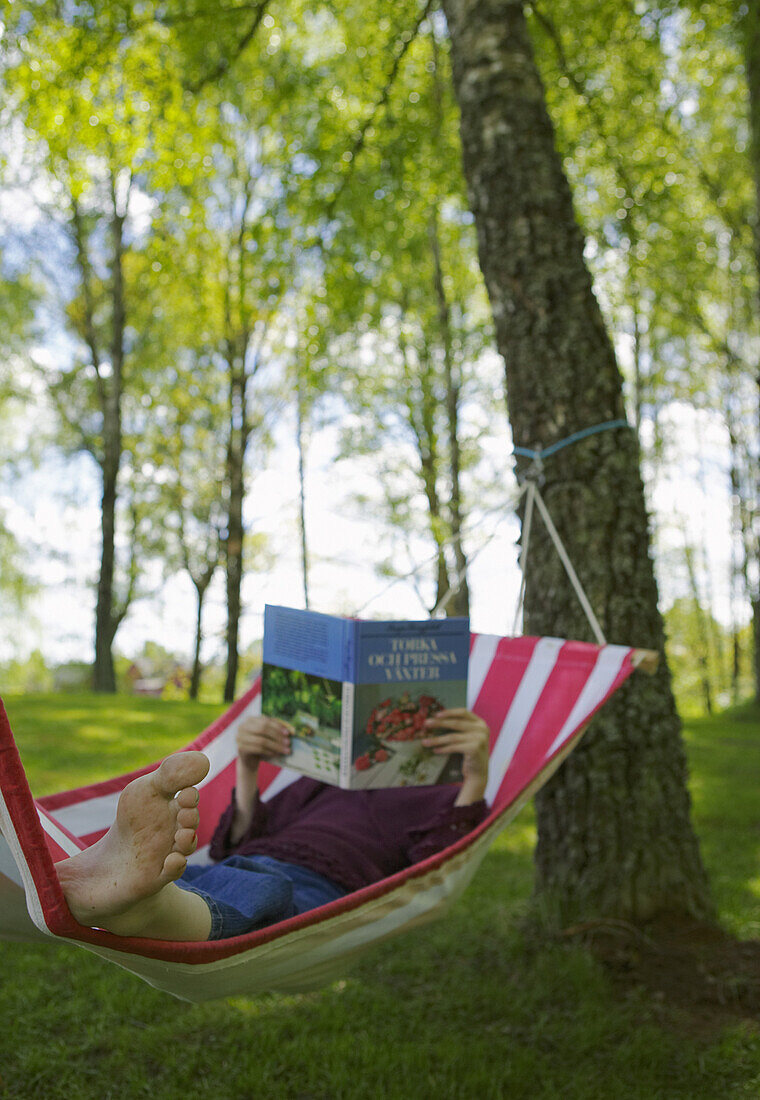 Girl reading book in hammock