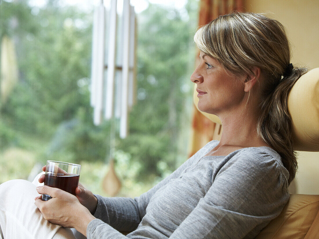 Woman relaxing in chair and drinking tea