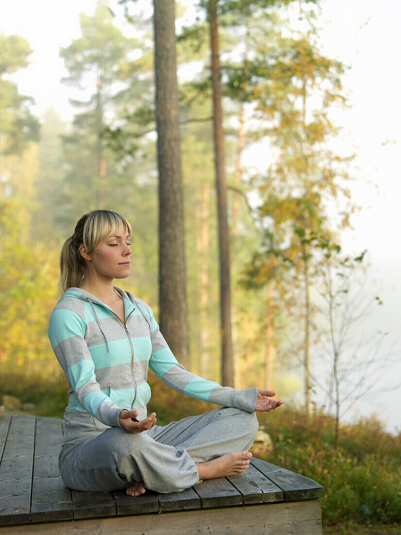 Woman meditates on terrace, Skåne, Sweden