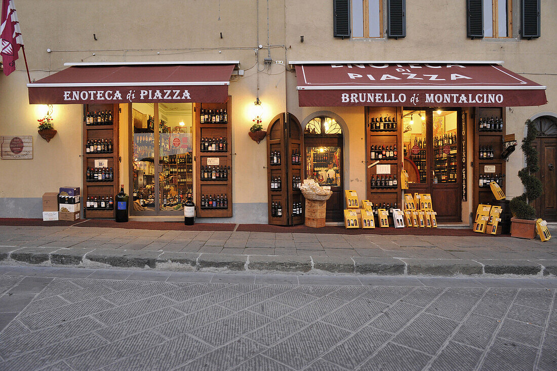 Blick auf beleuchtete Weinhandlung in Montalcino, südliche Toskana, Italien, Europa