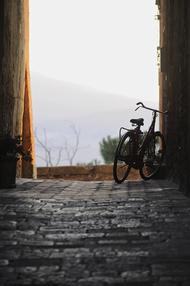 Bicycle in an alley in the evening light, Pienza, Tuscany, Italy, Europe