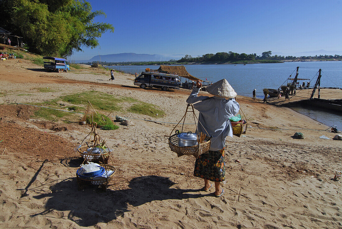 Women vendors selling food to bus passengers waiting for ferry, Champasak, Southern Laos, Asia