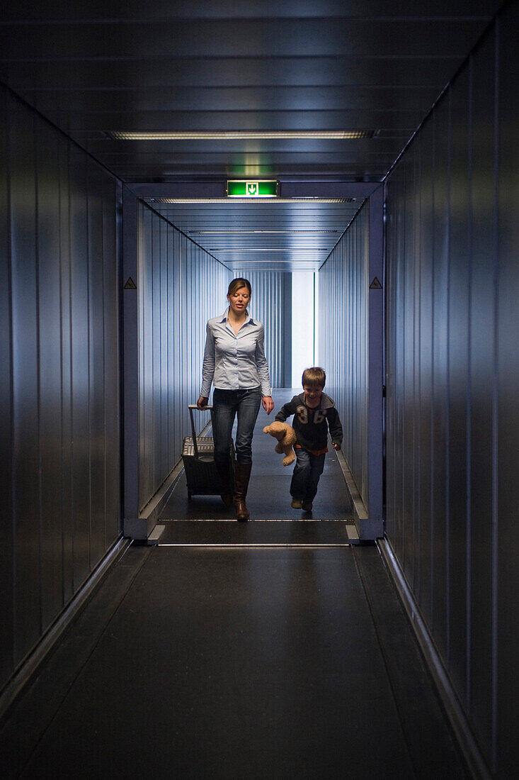 Mother and son passing gangway, Munich airport, Bavaria, Germany