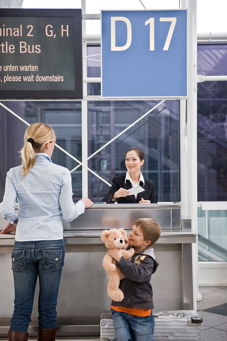 Mutter und Sohn beim Check-in, Flughafen München, Bayern, Deutschland