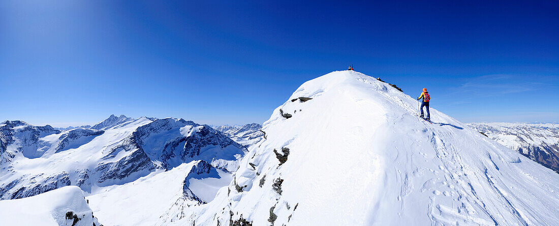 Skitourgeherin steigt zur Hocheisspitze auf, Großglockner im Hintergrund, Granatspitzgruppe, Hohe Tauern, Salzburg, Österreich