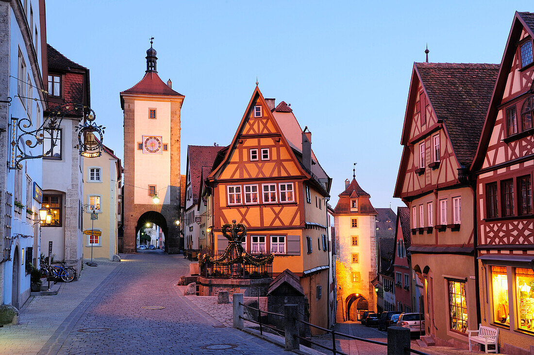 Illuminated Ploenlein with Sieberstor city gate in the evening light, Rothenburg ob der Tauber, Bavaria, Germany